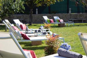 a group of lounge chairs sitting in the grass at Luxury Singular Villa Rosa in Padrón