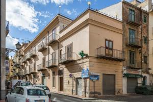 un bâtiment dans une rue avec des voitures garées dans la rue dans l'établissement Case Spazioscena - Calliope, à Castelbuono