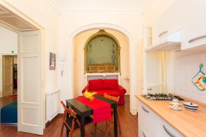 a kitchen with a table and a red couch at Case Spazioscena - Calliope in Castelbuono