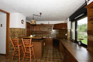a kitchen with wooden cabinets and a island with bar stools at LakeView Apartment in Preddvor