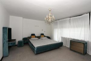 a bedroom with a bed with chairs and a chandelier at LakeView Apartment in Preddvor