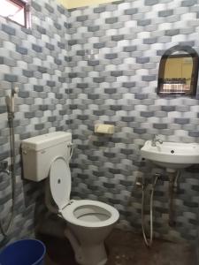 een badkamer met een toilet en een wastafel bij HOTEL ROYALE in Calcutta