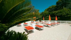 a group of tables and chairs with orange umbrellas at I giardini di Santomaj in Leporano