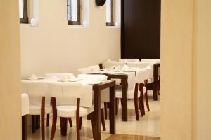 uma sala de jantar com mesas brancas e cadeiras brancas em Hotel Palladio em Vicenza
