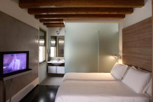 a bedroom with a bed and a tv on a wall at Hotel Palladio in Vicenza