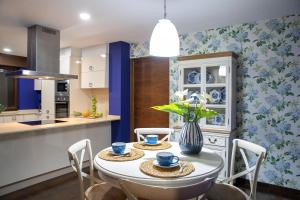 uma cozinha e sala de jantar com mesa e cadeiras em Luxury Singular Villa Carolina em Corrubedo