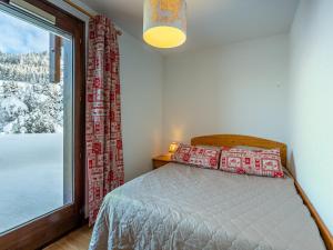 a bedroom with a bed and a large window at Appartement La Clusaz, 2 pièces, 4 personnes - FR-1-437-78 in La Clusaz