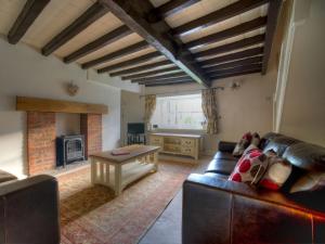 a living room with a couch and a fireplace at Kings Head Cottage in Pickering