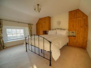 a bedroom with a bed and wooden cabinets and a window at Kings Head Cottage in Pickering