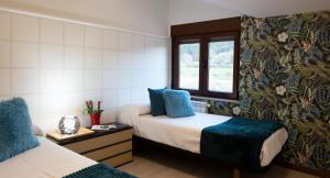 um quarto com 2 camas e uma janela em Luxury Singular Villa Carolina em Corrubedo