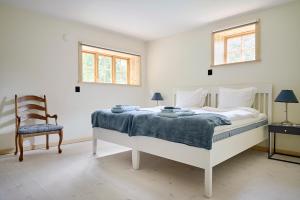 - une chambre avec un lit, une chaise et deux fenêtres dans l'établissement Spectacular 6-bed house in beautiful manor park, à Mariefred