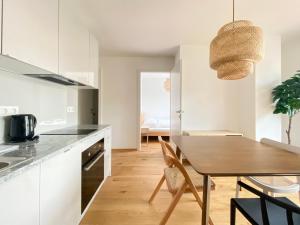 cocina y comedor con mesa de madera en STAD10 - Apartments very close to subway U2 Stadlau, en Viena