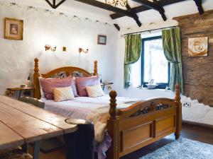 um quarto com uma cama de madeira e uma mesa de madeira em The Old Tea Shop em Scarfskerry