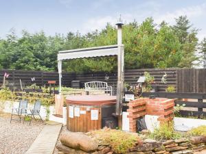 a backyard with a brick fireplace and a gazebo at The Old Tea Shop in Scarfskerry