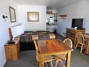 1 dormitorio con cama, mesa y escritorio en Eagle's Nest Motel en Priest River