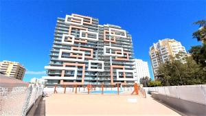 un edificio alto con una piscina di fronte di Elite Residence 2C a Portimão