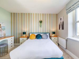 a bedroom with a white bed with pillows on it at Violet Place in Broomfield