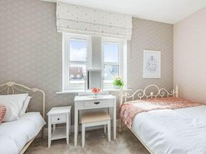 a bedroom with two beds and a table and a window at Violet Place in Broomfield