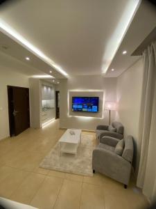 sala de estar con 2 sofás y TV en 7 Days Hotel en Umm Uthainah