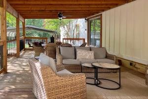 a patio with couches and tables on a porch at Broken Bow Home 2 Mi to Beavers Bend State Park in Broken Bow