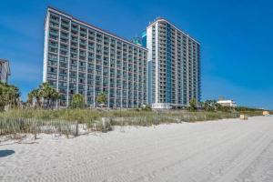 a large building on the beach with a sandy beach at 2 Bedroom Condo Amazing Views - Updates Galore in Myrtle Beach