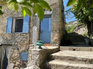 a stone house with a green vase in front of it at Domaine du Cruvelet Grand gite in Trigance