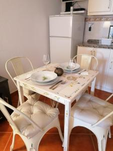 un tavolo bianco con sedie, piatti e bicchieri da vino di A Casa Pequenina - Escusa, Marvão a Marvão