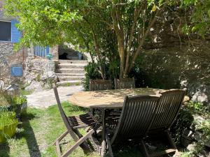 un tavolo e due sedie seduti intorno ad un albero di Domaine du Cruvelet Grand gite a Trigance