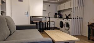 uma sala de estar com um sofá e uma máquina de lavar e secar roupa em Appart Jardin en Ville Cœur de Nantes em Nantes