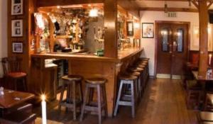 a bar in a restaurant with stools in a room at The White Lady Hotel in Kinsale