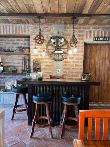a kitchen with a large bar with stools at Hacienda Santa Ana Lodging in Guamote