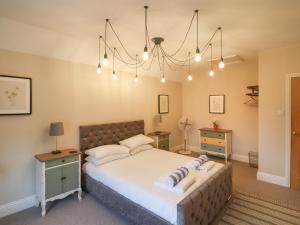 a bedroom with a large bed and a chandelier at Hall Farm in Market Rasen