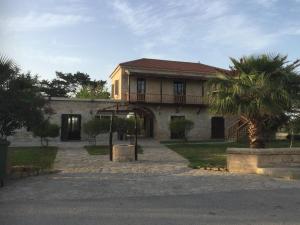 a house with a palm tree in front of it at Karpaz Arch House Hotel in Rizokarpaso