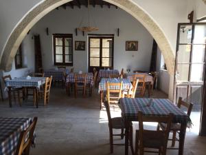 a dining room with tables and chairs and an archway at Karpaz Arch House Hotel in Rizokarpaso