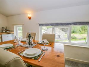 uma mesa de jantar com pratos e copos em Newfield Apartment 1 em Broughton in Furness