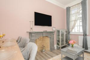 uma sala de estar com lareira e televisão de ecrã plano em The Stannary em Helston
