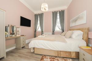 a bedroom with a bed and a desk and a television at The Stannary in Helston