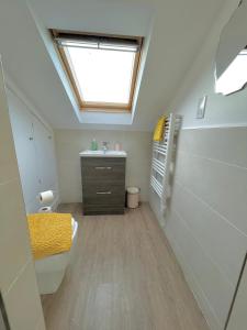 a bathroom with a sink and a skylight at La Fontaine Court Apartments - Aldershot in Aldershot