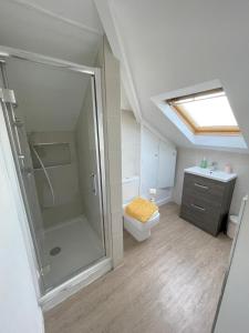 een badkamer met een douche, een toilet en een wastafel bij La Fontaine Court Apartments - Aldershot in Aldershot