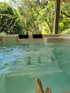 uma pessoa numa piscina com os pés na água em Pousada Maritacas do Sana em Sana