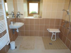 a tiled bathroom with a sink and a shower at Ferme Cidricole Hugues Desfrièches in Sainte-Marguerite-de-Carrouges