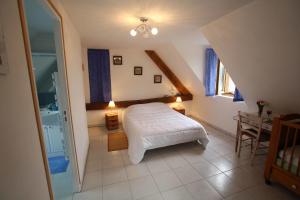 a bedroom with a white bed in a attic at Ferme Cidricole Hugues Desfrièches in Sainte-Marguerite-de-Carrouges