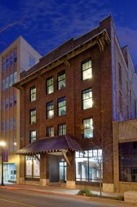 a large brick building on a city street at night at Sleepover Studio Apartments Downtown Springfield in Springfield