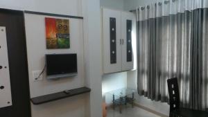 a living room with a flat screen tv on a wall at Hotel Royal Residency Executive in Miraj