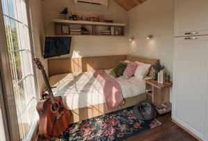 a bedroom with a bed and a guitar in it at 1001 Village in Jugureni
