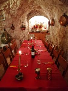 a long table with a red tablecloth and candles on it at La grotta di NiMa in Pretoro