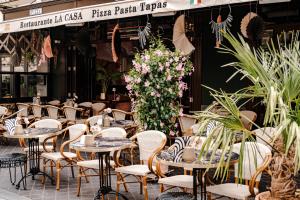 a restaurant with tables and chairs and flowers at Hotel La Casa in Valkenburg