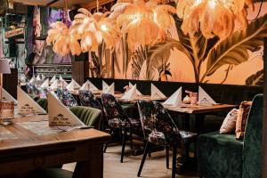 un comedor con mesas, sillas y lámparas de araña en Hotel La Casa, en Valkenburg