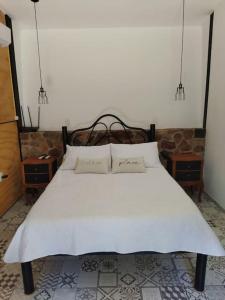 a bedroom with a white bed with two pillows at Apartamento Dos hermanas in Colonia Estrella