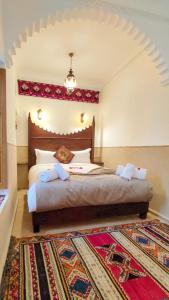 a bedroom with a large bed with a rug at RIAD DAR En-Nawat in Marrakesh